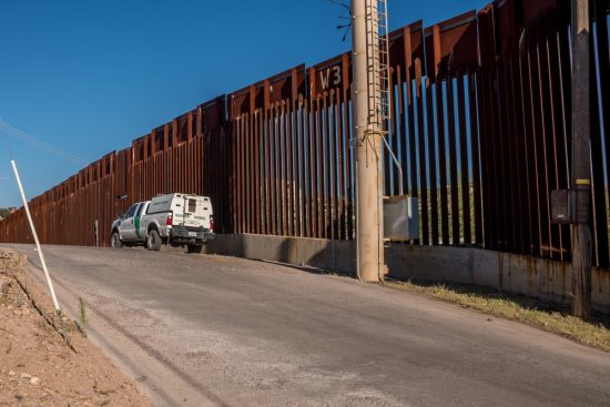 Migrante queda atrapado en muro fronterizo